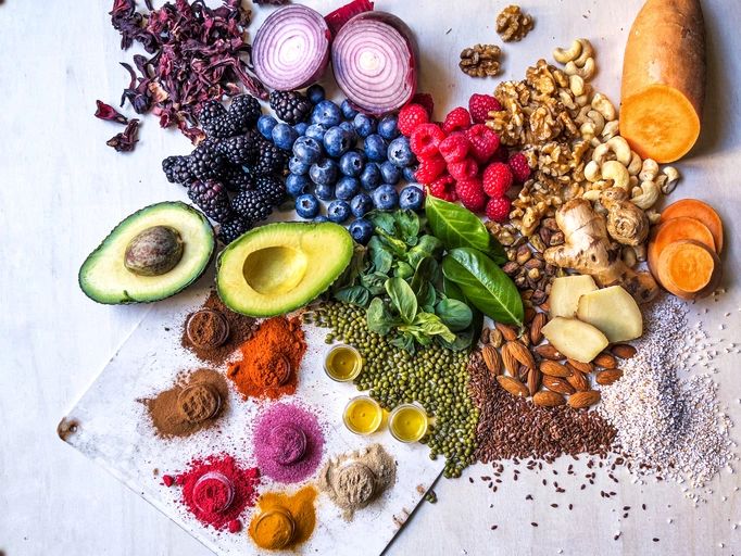 Colorful vegetables, fruits, legumes, nuts, and spices arranged on a table