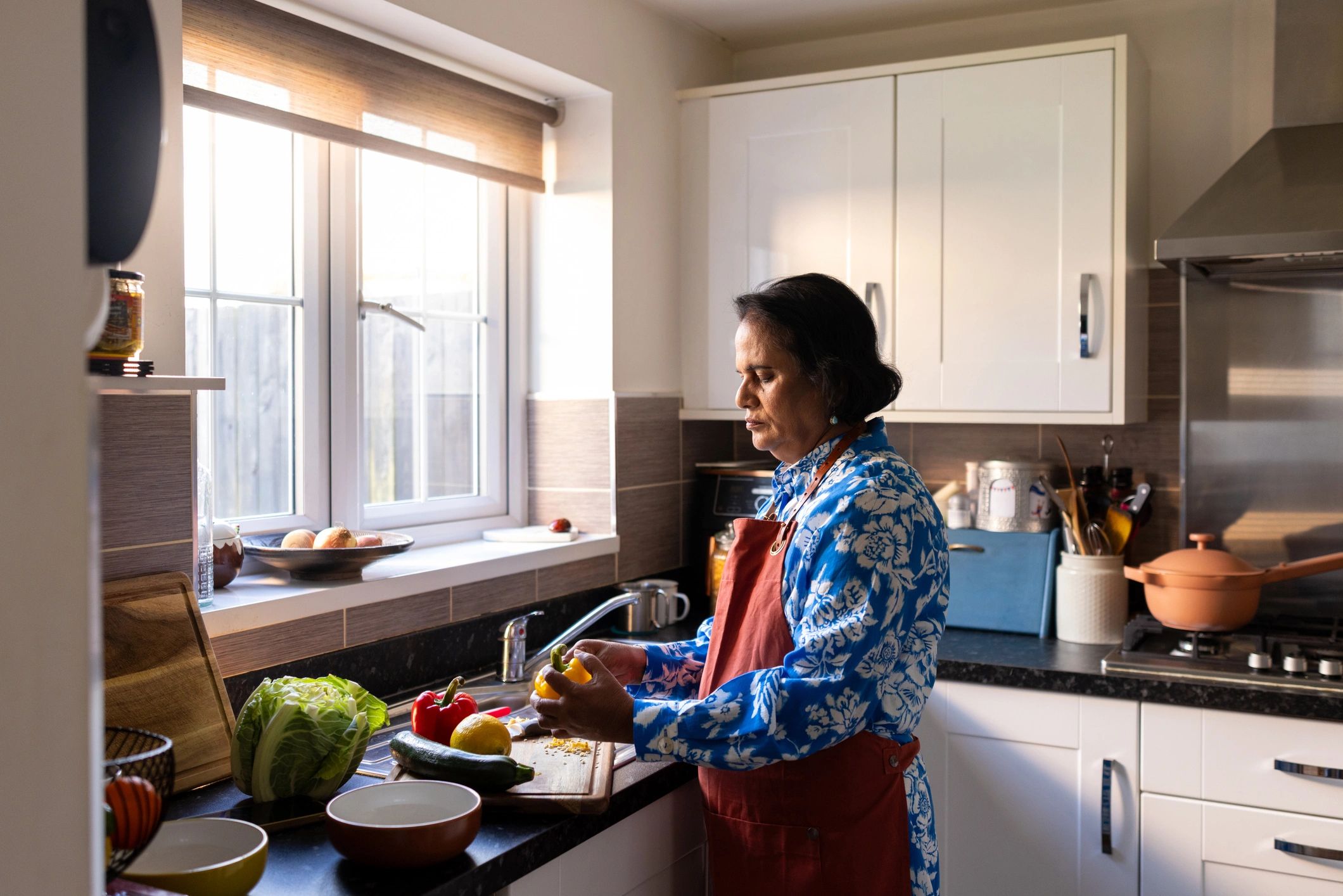Older woman cooking a healthy meal in a bright kitchen