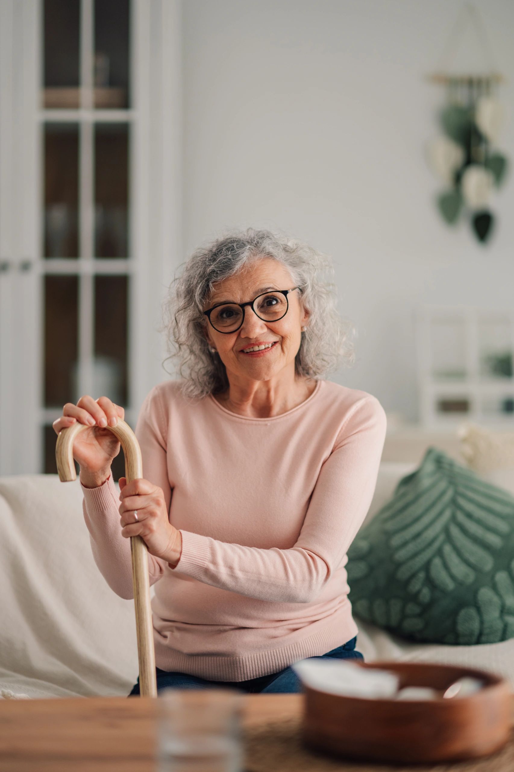 Senior woman smiling at home with a walking cane
